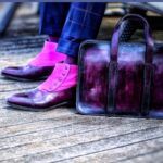 personnalisation de son look avec la patine du cuir à la carte : des bottines Balmoral à boutons et un porte-documents violets.